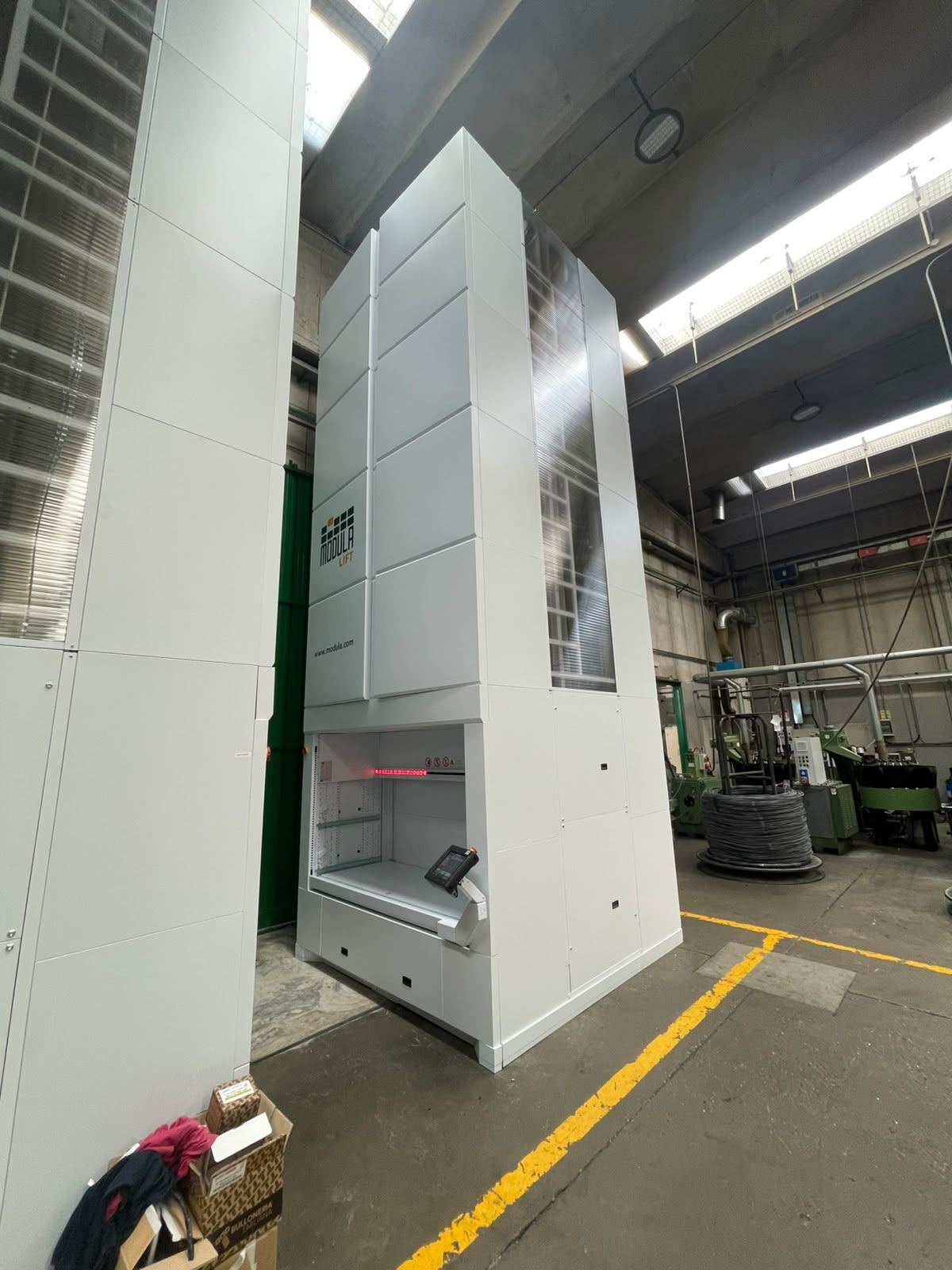 Magazzino verticale installato in uno stabilimento produttivo, con corsie di sicurezza segnalate