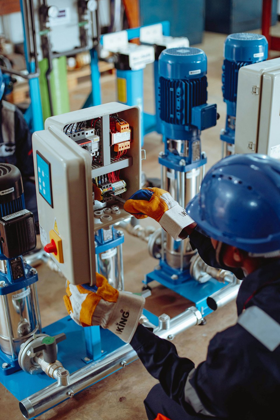 Un tecnico lavora su un quadro elettrico aperto con cavi.